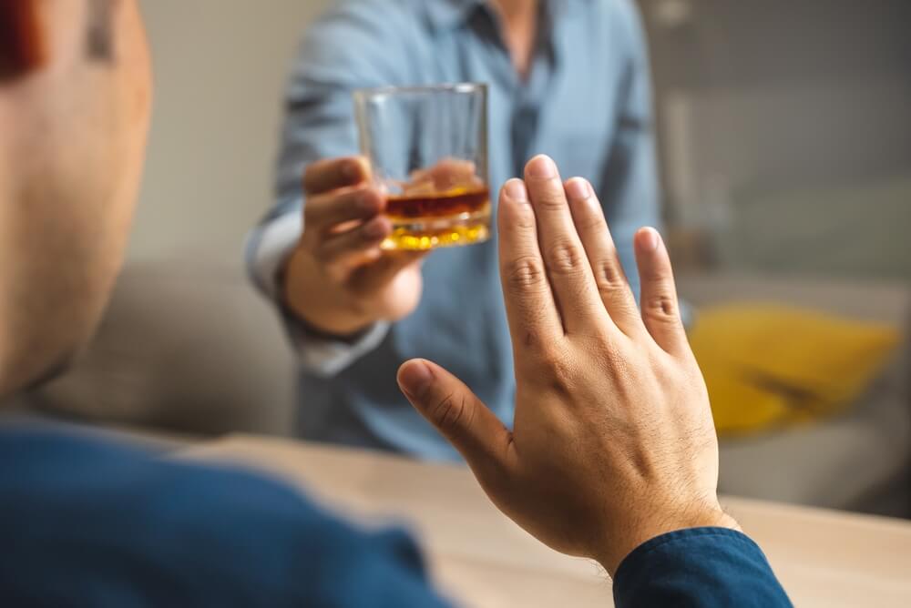 a hand saying stop to an offer of an alcoholic beverage representing the moderation trends in American society.