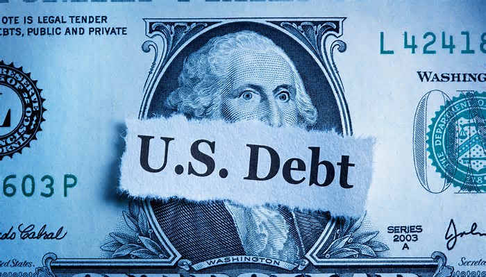 US dollar bill with a sign that says US Debt