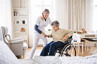 caregiver providing help to a senior struggling to get out of a wheel chair